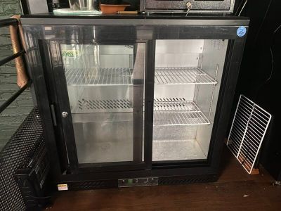 an image of a glass door refrigerator in a kitchen