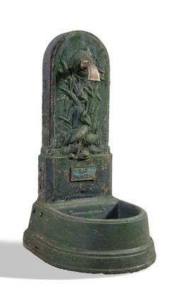 a green water fountain with a statue on it