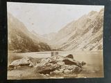 a black and white photo of a lake in the mountains
