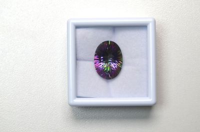 un diamant violet dans une boîte blanche posée sur une surface blanche
