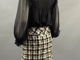 a black and white plaid skirt with a black blouse on a mannequin mannequin mannequin mannequin mannequin mannequin manne