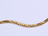 un serpent doré allongé sur une surface blanche