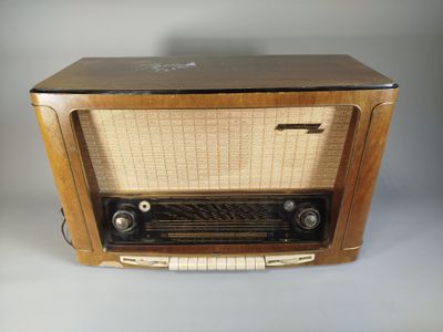 an old fashioned radio sitting on top of a white table