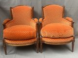 une paire de fauteuils rembourrés orange sur fond gris