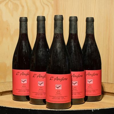 six bottles of red wine are lined up on a barrel
