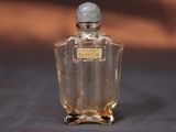 une photo d'un petit flacon de parfum posé sur une table