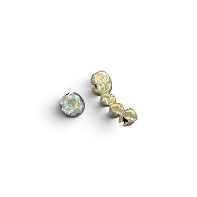 deux boucles d'oreilles en argent et en or posées sur un fond blanc