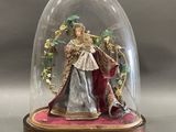 une figurine représentant une femme sous une cloche en verre