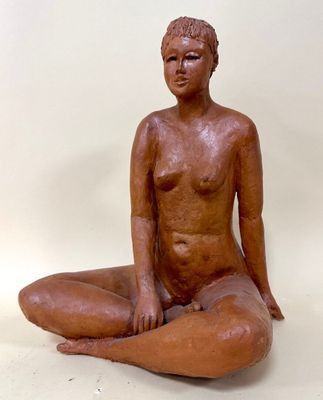 a statue of a woman sitting on the ground