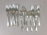 six forks and six knives are arranged in a row on a table