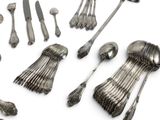 a lot of silver spoons and spoons on a white surface