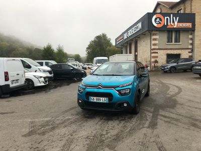 a small blue car parked in front of a building