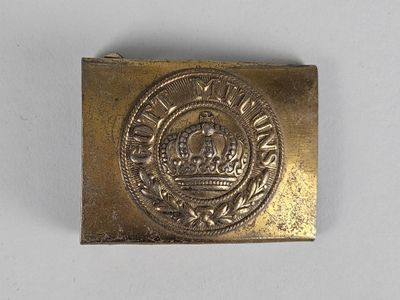 un gros plan sur une boucle de ceinture en or ornée d'une couronne