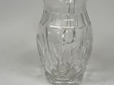 a clear glass pitcher with a silver lid on a white surface