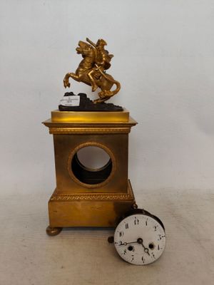 Pendule en bronze et laiton doré surmontée d'un sujet " Bona…