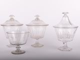 trois vases en verre transparent avec leurs couvercles, posés sur un plan de travail blanc