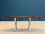 an image of a wooden table with metal legs on a concrete floor