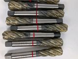 four pieces of drill bits are lined up on a table