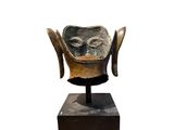 an image of a sculpture of a face on a wooden base