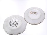 two white plates with black writing on them on a white surface