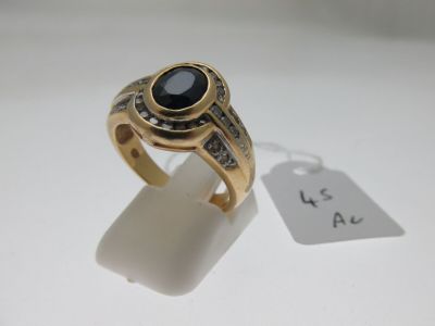 Gros plan sur une bague en or ornée d'une pierre noire
