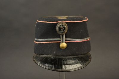 un chapeau noir orné d'un bouton doré