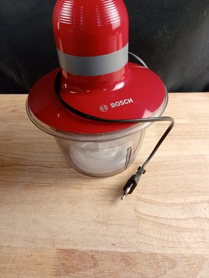 un mixeur rouge surmonté d'un chapeau rouge
