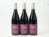 trois bouteilles de vin posées sur une table blanche