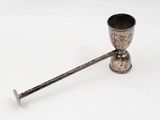 une coupe ancienne en argent, dotée d'une poignée en métal sur un fond blanc
