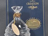 une photo d'un flacon de parfum « Creation » à côté d'une boîte