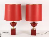 une paire de lampes en verre rouge avec des pieds en laiton et des abat-jours rouges