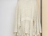 an image of a white sweater hanging on a clothes rack