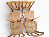 four wooden rocking chairs with wicker seats against a white wall