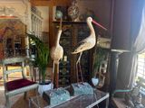 two statues of birds sitting on top of a glass table