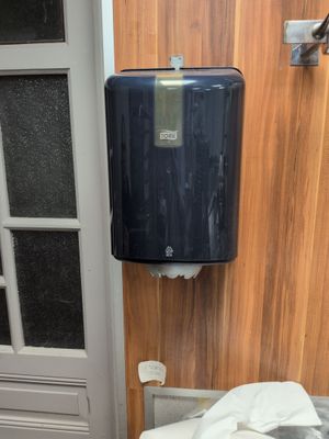 a toilet and a paper towel dispenser in a bathroom
