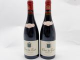 deux bouteilles de vin rouge posées l'une à côté de l'autre sur une surface blanche