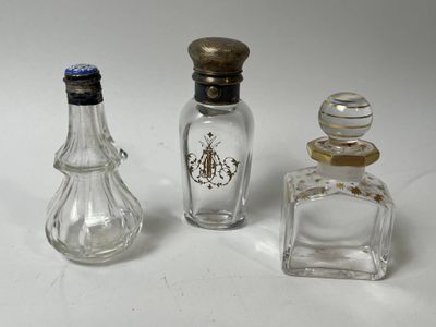 trois petites bouteilles en verre et une petite bouteille en verre posées sur une surface blanche