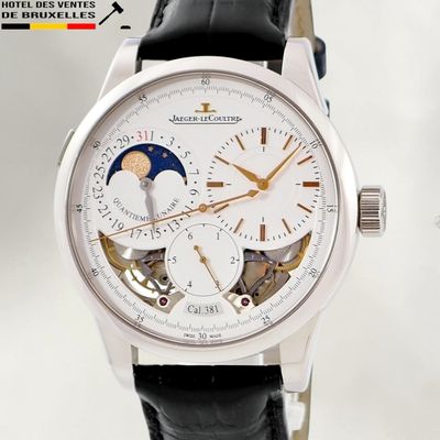 a watch with a white dial and a black leather strap