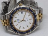 a silver and gold watch with a blue bezel