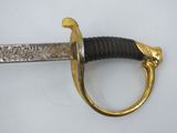 an image of a gold and black sword on a white surface