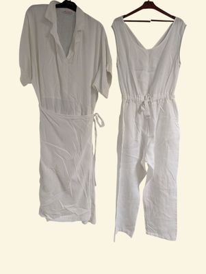 pair of white jumpsuits hanging on a hanger on a white background