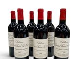 four bottles of red wine are lined up on a white surface