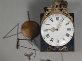 une horloge posée sur une table à côté de quelques outils