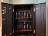 a black cabinet with a bunch of guns in it