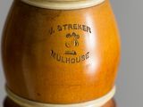 a brown vase with a brown handle on a stand