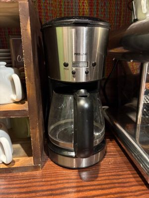 une cafetière posée sur une table en bois à côté d'une autre cafetière