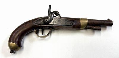 un vieux fusil exposé sur une surface blanche