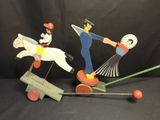 figurines en bois représentant un homme à cheval et une femme à cheval sur une balançoire à bascule