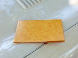 a yellow wallet sitting on the hood of a white car