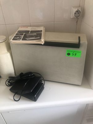 un petit réfrigérateur posé sur un plan de travail, à côté d'un téléphone